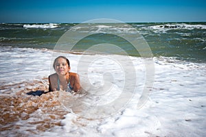 Pleased pretty little girl enjoys warm sea water