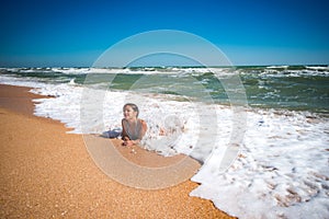 Pleased pretty little girl enjoys warm sea water