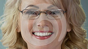 Pleased senior female patient smiling after teeth whitening procedure, closeup