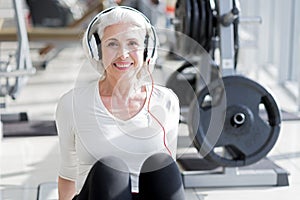 Pleased senior woman listening to music after workout.