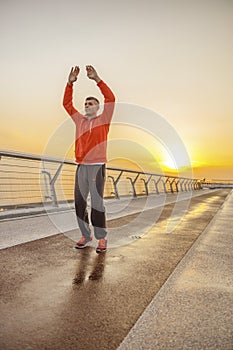 Pleased sportive cute man stretching his muscles