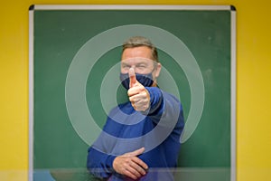Pleased teacher signalling success with thumb up