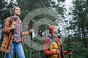 pleased woman holding hiking sticks and