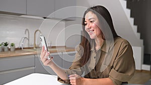 Pleased young asian woman has video call on the smartphone