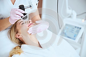 Patient smiling during the skin rejuvenation procedure photo