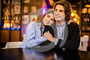 Pleased young loving couple in cafe hugging