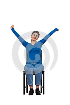 Pleased young woman sitting on a chair and relax,  hands outstretched and eyes closed. Cheerful girl dreaming isolated over white
