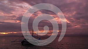 Pleasure boat on a background of cloudy purple sunset.