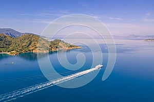 Pleasure boat cruising to island in Aegean sea