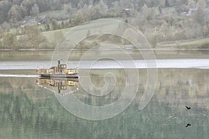 Pleasure boat in the early misty morning on the Grundlsee lake. Town of Grundlsee, Austria