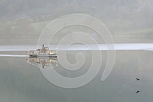 Pleasure boat in the early morning on the Grundlsee lake. Town of Grundlsee, Austria.