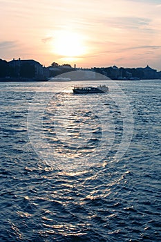 Pleasure boat floats on the river at sunset