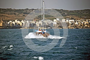 A pleasure boat with lots of sightseers aboard heading back to the sea .