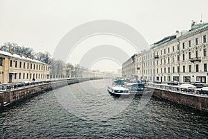 pleasure boat is moored on the river in a spring snowstorm