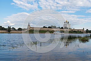 Pleasure boat on the river Velikaya opposite Trinity cathedral in Pskov Krom Kremlin. Russia