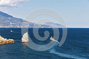 Pleasure boats on the background of sea and rocks.
