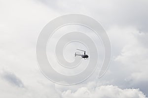 Pleasure helicopter in blue during a tourist flight in the sky with clouds. non-flying weather with the likelihood of a disaster