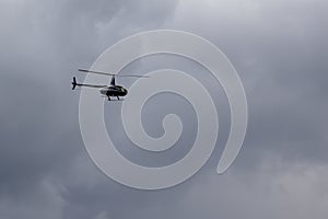 Pleasure helicopter in blue during a tourist flight in the sky with clouds. non-flying weather with the likelihood of a disaster