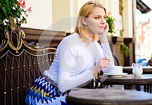 Pleasure on her mind. Woman blonde dreamy smiling face having coffee, urban background defocused. What do girls dream