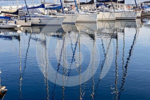 Pleasure yacht masts in the water reflection on Lake Garda in Italy