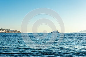 Pleasure yacht on the sea surface on a sky background