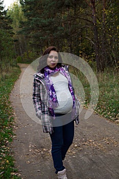 Pleasured pregnant woman autumn park