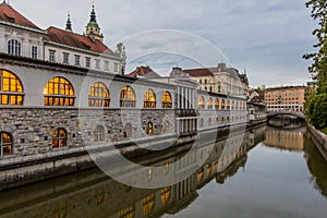 Plecnik arcade market building reflecting in Ljubljanica river in Ljubljana, Sloven