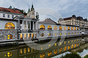 Plecnik arcade market building reflecting in Ljubljanica river in Ljubljana, Sloven