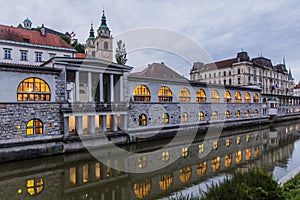 Plecnik arcade market building reflecting in Ljubljanica river in Ljubljana, Sloven