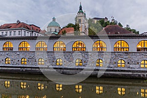 Plecnik arcade market building reflecting in Ljubljanica river in Ljubljana, Sloven