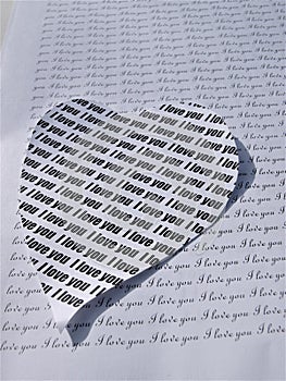 Plenty of love words in black on white paper and a heart