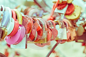 Plenty of multicolored love padlocks on metal railing of the bridge. selective focus, toned