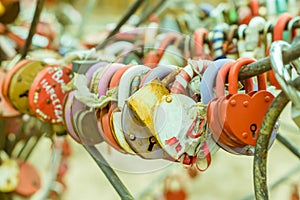 Plenty of multicolored love padlocks on metal railing of the bridge. selective focus, toned