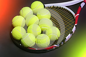 Plenty of tennis Balls on Tennis Racquet Strings against Black b