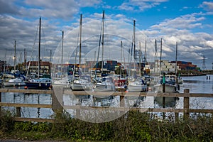 A plethora of pleasure boats with a backdrop of containers at Eling Marina near Southampton, UK