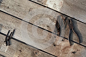 Pliers and bent nails old lie on a tree desktop. rust. cracked, scratched homemade table. construction background