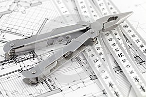 Pliers, folding ruler and architectural plan