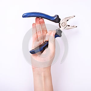 Pliers in the hand of a girl. Symbol of hard work, feminism and labor day. Isolate on white background