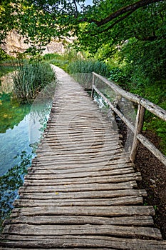 Plitvice, Croatia - Wooden walkway in Plitvice Lakes National Park on a bright summer day with crystal clear turquoise water