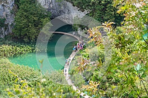 Plitvice Lakes National Park in Croatia. View from Above. Tourists Enjoy the Tour on the Wooden Pathway.