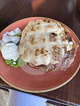 pljeskavica filled with cheese popular pork dish in balkan plate with pita bread photo