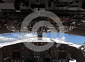 Pllane is flying above white clouds on blue sky view from pilots cabin