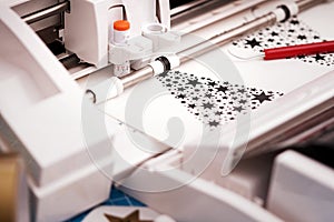 plotting machine makes large christmas stickers arranged from star symbols out of black adhesive vinyl film.