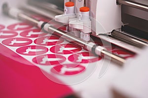 plotting machine makes multiple stickers with peace dove symbol from pink adhesive foil