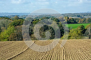 Ploughed field with  furrows overlooking English countryside