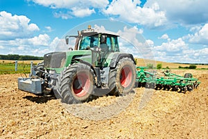 Ploughing tractor at field cultivation work photo