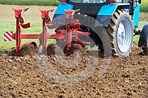 Ploughing tractor at field cultivation work photo