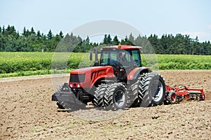 Ploughing tractor at field cultivation work