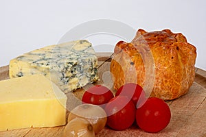 Ploughmans lunch on a wooden board.