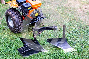 Plow and hiller complete with a walk-behind tractor for agricultural work.